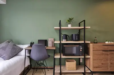 a bedroom with a bed and a desk with a microwave at CraftFlat Komagome 502, a compact studio at excellent location in Tokyo