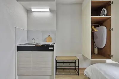 a small kitchen with a sink and a bed at CraftFlat Komagome 502, a compact studio at excellent location in Tokyo