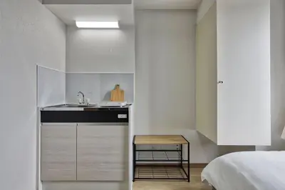 a small kitchen with a sink and a bed at CraftFlat Komagome 502, a compact studio at excellent location in Tokyo