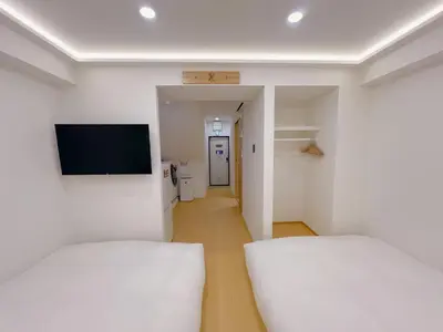 a room with two beds and a flat screen tv at star house akihabara ueno tokyo in Tokyo