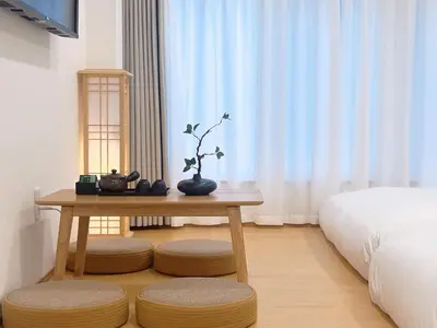 a table in a room with a bed and a table with a plant at star house akihabara ueno tokyo in Tokyo