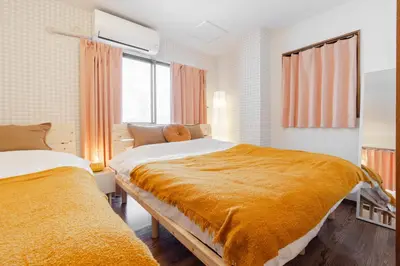 a bedroom with two beds with orange blankets at Casita Dulce in Tokyo