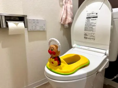 a toy monkey sitting on a toilet in a bathroom at Motosakura 301, direct access to Narita and Haneda, 2 beds, 5 train lines, elevator, free bicycle rental, luxury double bed in Tokyo