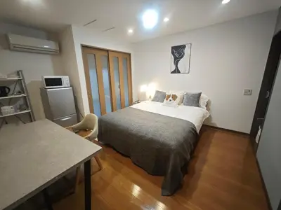 a small bedroom with a bed and a table at ZYZ Higashijūjō 101 KI0482 in Tokyo
