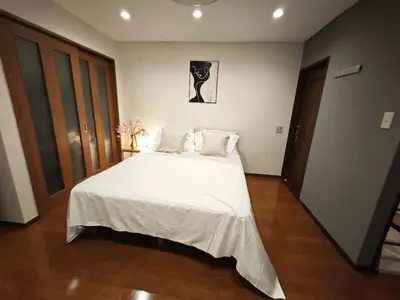 a bedroom with a large bed with white sheets and pillows at ZYZ Higashijūjō 101 KI0482 in Tokyo