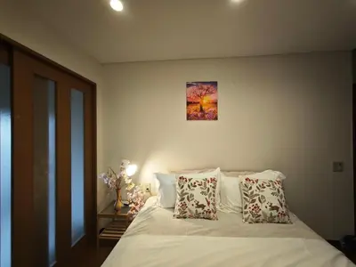 a bedroom with a bed with white sheets and pillows at ZYZ Higashijūjō 101 KI0482 in Tokyo