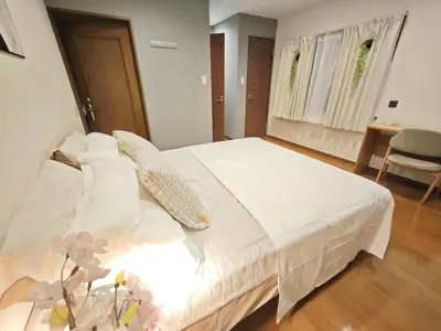 a bedroom with a white bed and a desk at ZYZ Higashijūjō 101 KI0482 in Tokyo