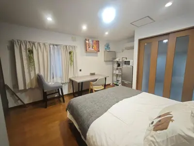 a bedroom with a bed and a desk in it at ZYZ Higashijūjō 101 KI0482 in Tokyo