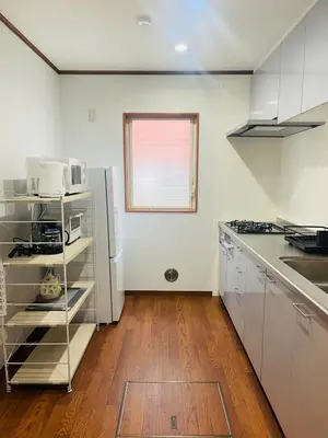 a kitchen with white appliances and a wooden floor at New Tokyo Asakusa Area Emi House in Tokyo