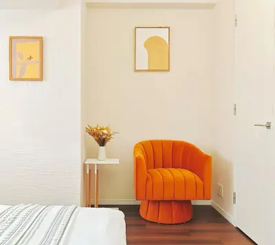 an orange chair sitting in a corner of a bedroom at \u9326\u7cf8\u753a-1104 in Tokyo
