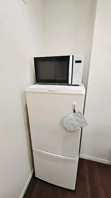 a microwave sitting on top of a white refrigerator at \u9326\u7cf8\u753a-1104 in Tokyo