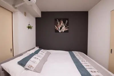 a bedroom with a white bed with a black wall at Ikebukuro\u4e2d\u5ddd405-TS0041 in Tokyo