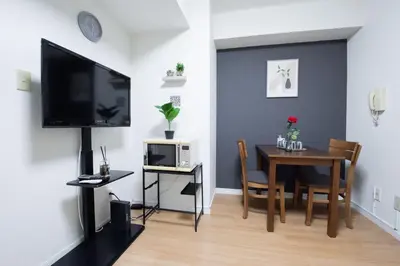 a dining room with a table and a television on a wall at Ikebukuro\u4e2d\u5ddd405-TS0041 in Tokyo