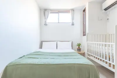 a bedroom with a bed with a green blanket at Skytree House Oshiage New 3-story Villa, 2 Showers, 2 Toilets, 4 Rooms, 3 min walk to Oshiage Station in Tokyo