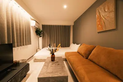 a living room with a couch and a bed at IKISUMI HOTEL in Otsuka in Tokyo