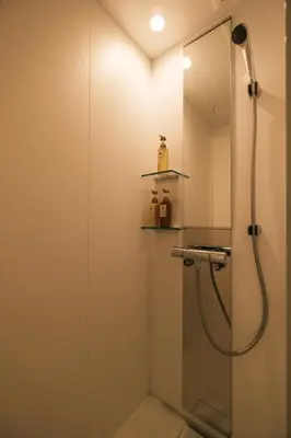 a bathroom with a shower with a glass door at IKISUMI HOTEL in Otsuka in Tokyo