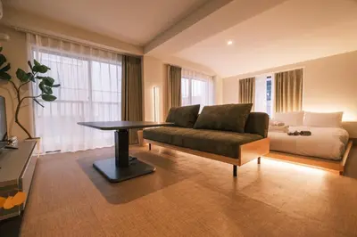 a living room with a couch and a bed at IKISUMI HOTEL in Otsuka in Tokyo