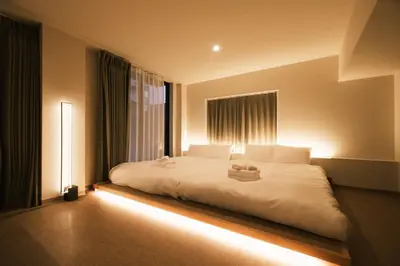 a bedroom with a large white bed with lights on it at IKISUMI HOTEL in Otsuka in Tokyo
