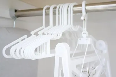 a closet with white utensils hanging from a rod at Tower View Stay Kinchicho in Tokyo