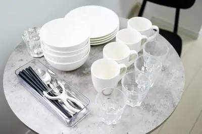 a table with white plates and glasses on it at Tower View Stay Kinchicho in Tokyo