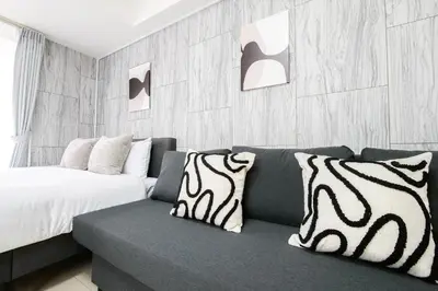 a living room with a couch and a bed at Tower View Stay Kinchicho in Tokyo
