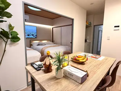a room with a table and a bedroom with a bed at Moto Sakura 502,Asakusa Ueno Great location 2 bedrooms,3 beds,6 Direct access to Narita and Haneda Airports,5 train lines available in Tokyo