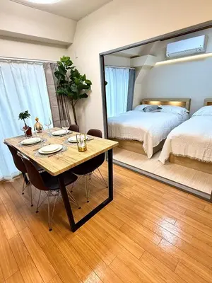 a room with a table and a bed and a mirror at Moto Sakura 502,Asakusa Ueno Great location 2 bedrooms,3 beds,6 Direct access to Narita and Haneda Airports,5 train lines available in Tokyo