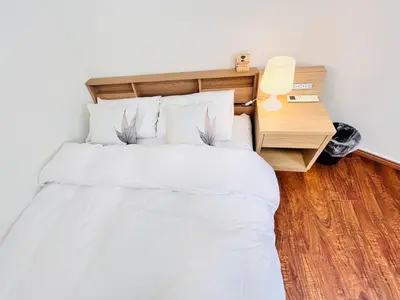 a bedroom with a large white bed with a night stand at LY-shinjuku-house SJ0432 in Tokyo
