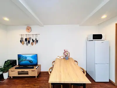 a kitchen with a wooden table and a refrigerator at LY-shinjuku-house SJ0432 in Tokyo