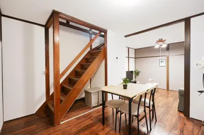 a dining area with a table and a staircase in a loft at Kotori Hinoki in Tokyo