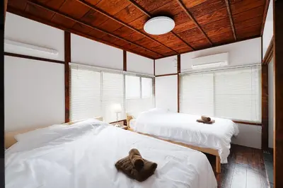 two beds in a room with windows at Kotori Hinoki in Tokyo