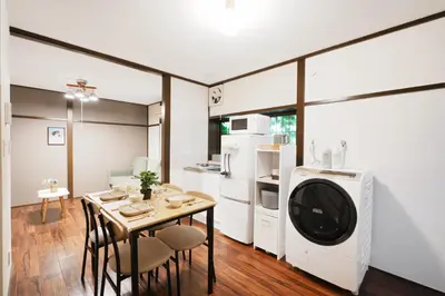 a kitchen and dining room with a table and a washing machine at Kotori Hinoki in Tokyo