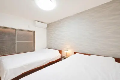 a bedroom with two beds and a window at Kotori Akasaka in Tokyo