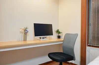 a computer monitor sitting on a desk with a chair at Kotori Akasaka in Tokyo
