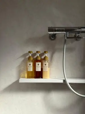 four bottles of oils on a shelf in a bathroom at M House 301 Tokyo Omori\u99c5 in Tokyo