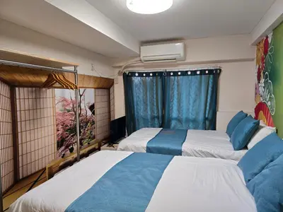 two beds in a room with a window at BandK Numabukuro 202 in Tokyo
