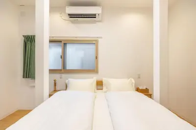 two beds in a room with a air conditioner at TaroTime Shinjuku Serene Japanese Cottage in Tokyo