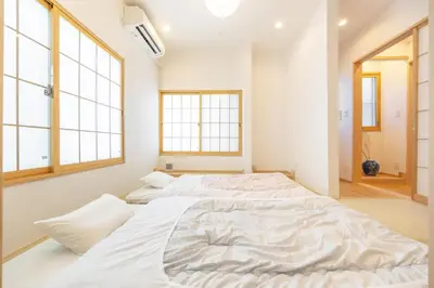 a large bed in a room with two windows at TaroTime Shinjuku Serene Japanese Cottage in Tokyo