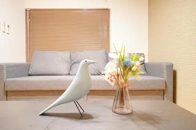 a white bird standing on a table with a vase of flowers at Monthly Only Kotori Akasaka Ideal Place for Long-term Stay and Workcation in Tokyo