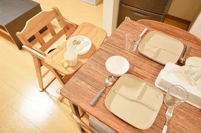 a wooden table with plates and wine glasses on it at Monthly Only Kotori Akasaka Ideal Place for Long-term Stay and Workcation in Tokyo