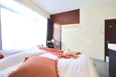 a bedroom with two beds and a large window at \u696d\u5e732\u968e3\u968e \u5c4b\u4e0a\u30b9\u30ab\u30a4\u30c4\u30ea\u30fc\u30d3\u30e5\u30fc \u6700\u59276\u540d in Tokyo