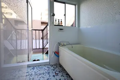 a bathroom with a bath tub next to a window at \u696d\u5e732\u968e3\u968e \u5c4b\u4e0a\u30b9\u30ab\u30a4\u30c4\u30ea\u30fc\u30d3\u30e5\u30fc \u6700\u59276\u540d in Tokyo