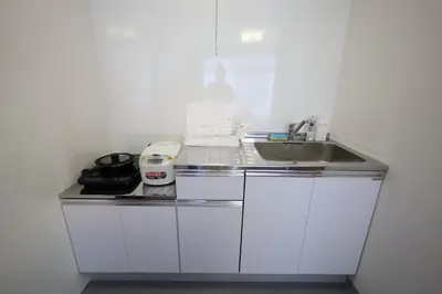a white kitchen with a sink and a counter at \u696d\u5e732\u968e3\u968e \u5c4b\u4e0a\u30b9\u30ab\u30a4\u30c4\u30ea\u30fc\u30d3\u30e5\u30fc \u6700\u59276\u540d in Tokyo