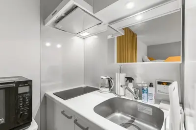 a kitchen with a sink and a microwave at 4\u540d\u5bbf\u6cca \u897f\u65b0\u5bbf\u30a2\u30d1\u30fc\u30c8\u30e1\u30f3\u30c8 in Tokyo