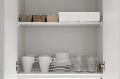a shelf with cups and plates and other dishes at 4\u540d\u5bbf\u6cca \u897f\u65b0\u5bbf\u30a2\u30d1\u30fc\u30c8\u30e1\u30f3\u30c8 in Tokyo