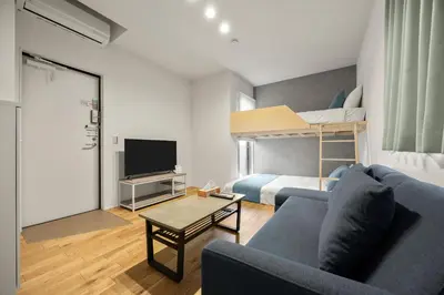 a living room with a couch and a bed at 4\u540d\u5bbf\u6cca \u897f\u65b0\u5bbf\u30a2\u30d1\u30fc\u30c8\u30e1\u30f3\u30c8 in Tokyo