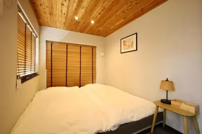 a bedroom with a bed and a wooden ceiling at \u4e1c\u4e0a\u91ce \u4e0a\u91ce\u99c5\u5f92\u6b696\u5206 \u8d85\u9ad8\u7d1a4\u968e\u5efa\u3066\u65b0\u7bc9\u4e00\u8ed2\u5bb6 \u6700\u592710\u540d in Tokyo