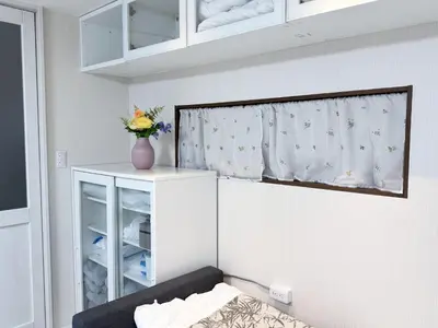 a bedroom with a bed and a vase of flowers on a curtain at Minamikoiwa, Edogawa City -3F-EG0477 in Tokyo