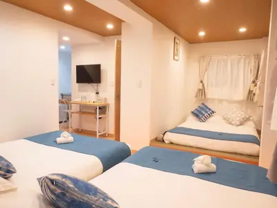 a bedroom with two beds and a television in it at \u685c\u306e\u5ddd71 \u521d\u53f0\u99c55\u5206 2-6\u4eba\u4e285 minute from Hatsudai 2-6 people in Tokyo