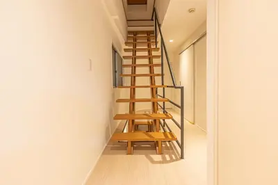a wooden staircase in a room with white walls at SUNRISE STAY Ebisu in Tokyo